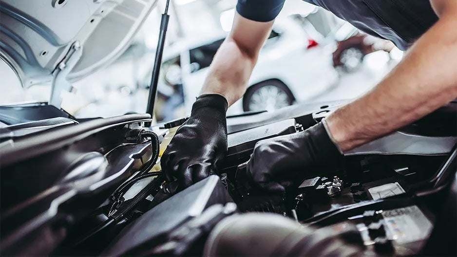 Technician working on vehicle at service center